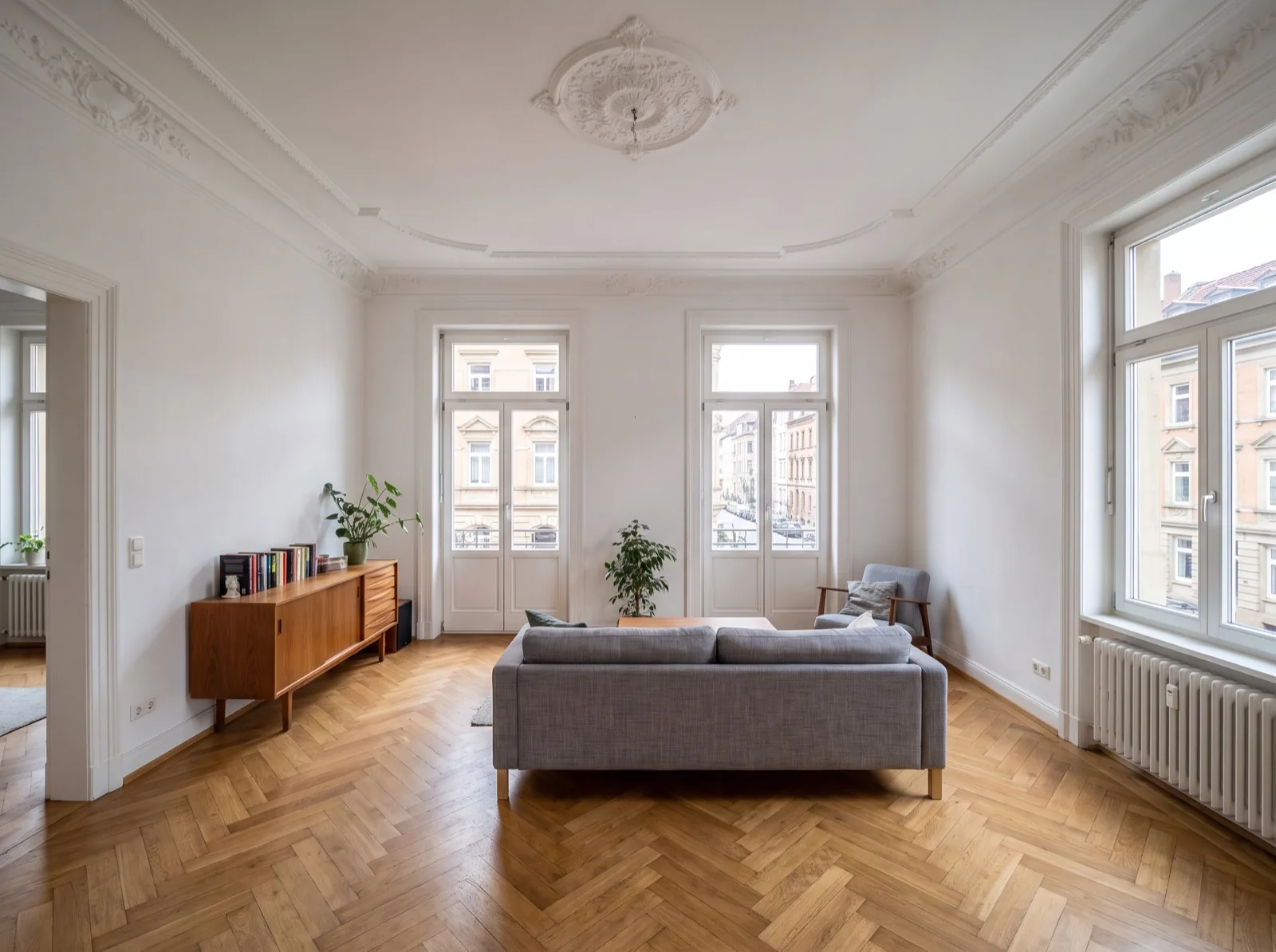 Demo-Ansicht im virtuellen Rundgang: Wohnzimmer im Stuttgarter Altbau mit Stuckdecke und Fischgrätparkett